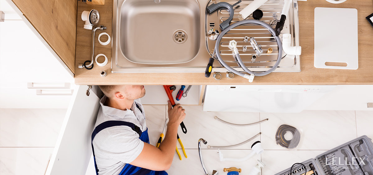plumber installs pipes under the sink