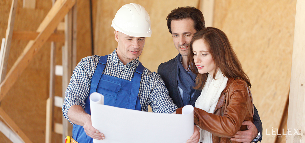 a man and a woman look at a house plan