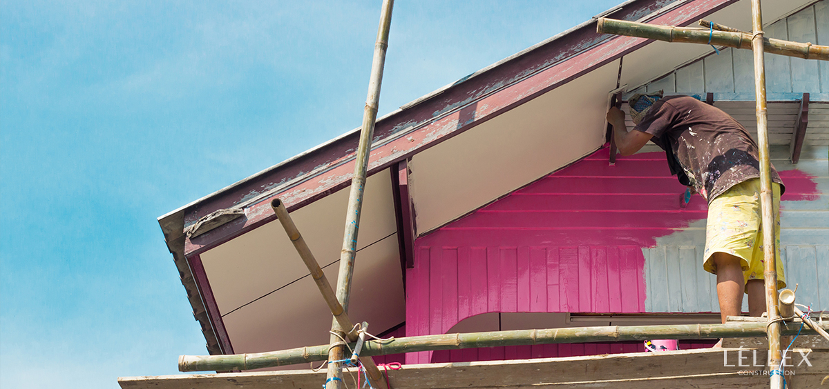 A man paints a house from the outside