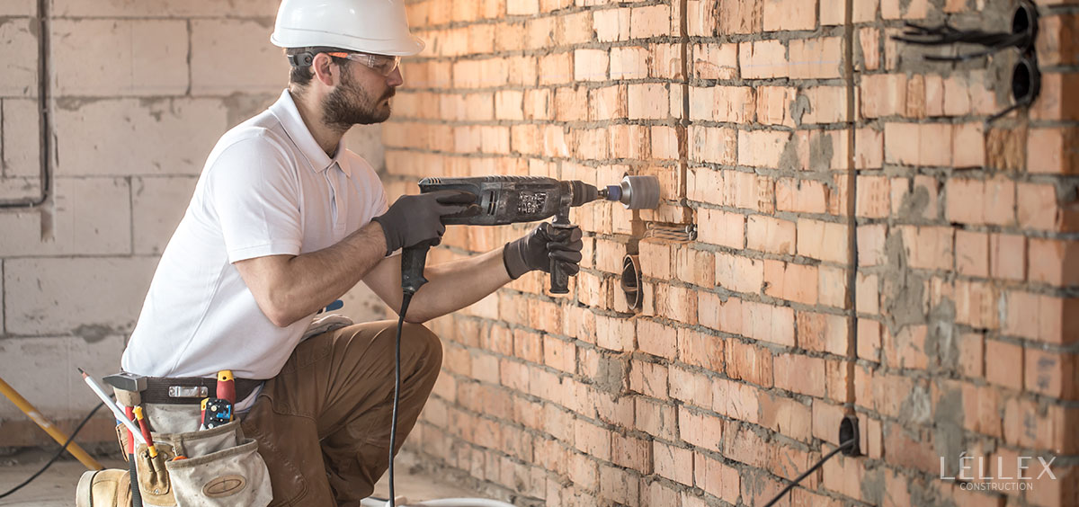 A man drills a wall to install sockets