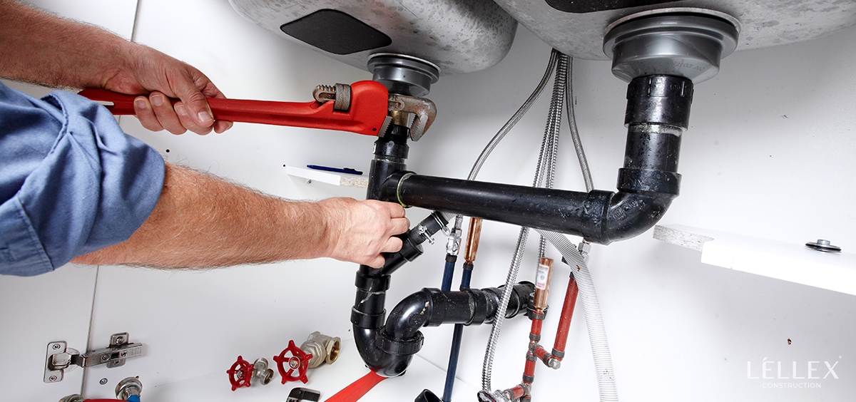 a man clamps a pipe under the sink