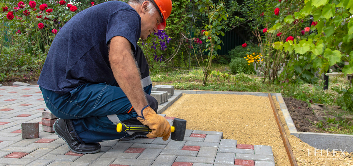 A builder lays paving stones