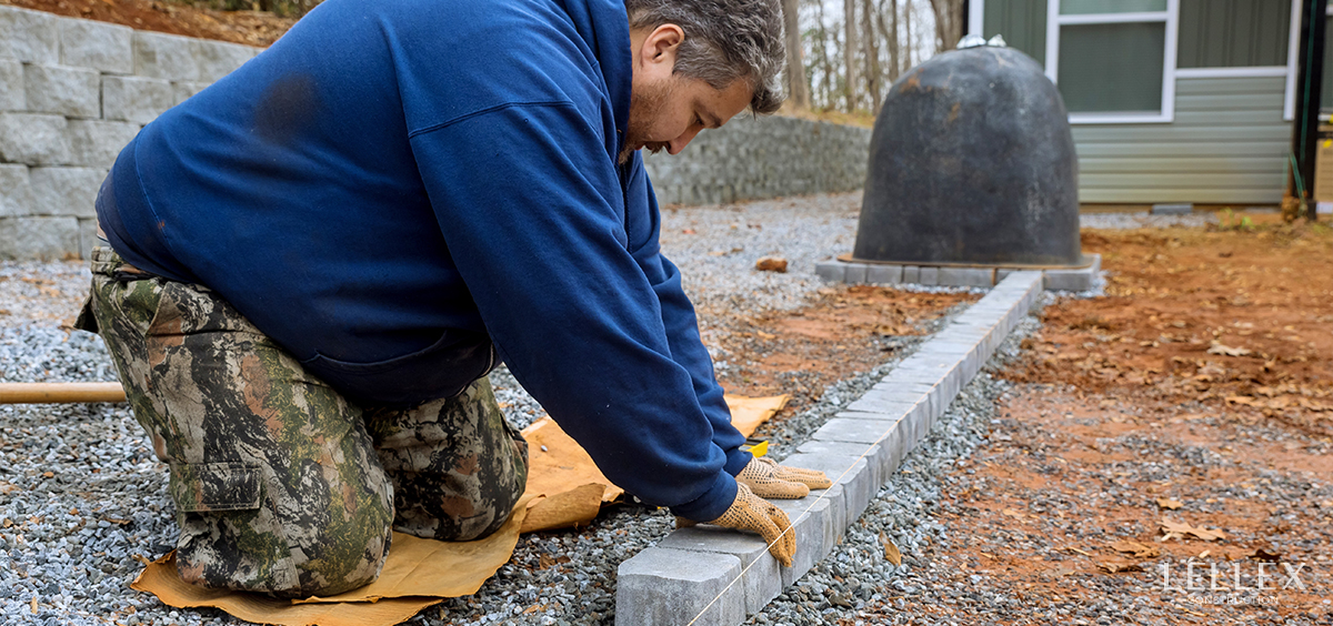 A builder lays paving stones for a house