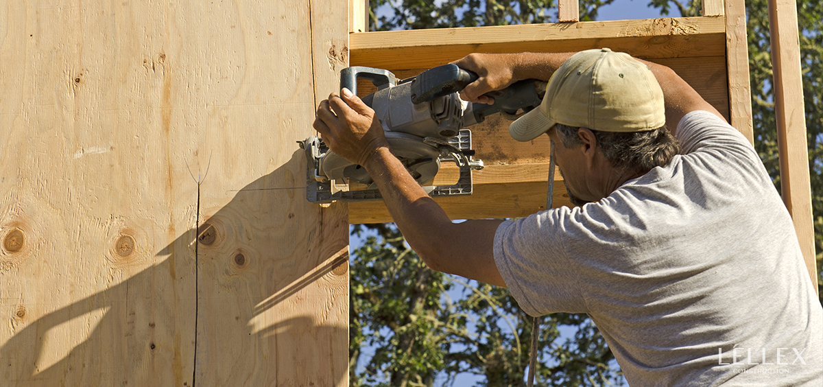 a man makes house cladding using a saw