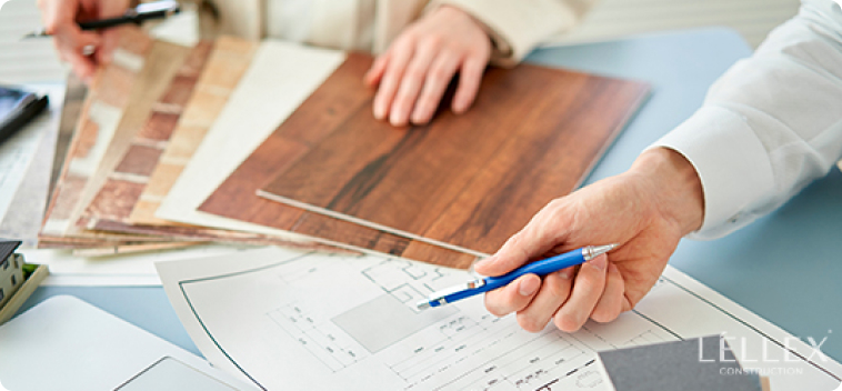 a man points with a pen to the drawings of a building